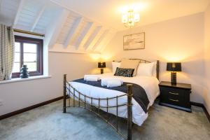 a bedroom with a bed and two lamps and a window at Laurel House - Pool, Sauna & Gardens - Sleeps up to 12 people by STAE-Homes in Magor
