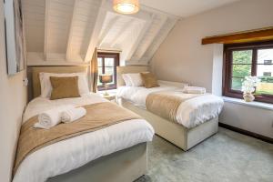 a bedroom with two beds and a window at Laurel House - Pool, Sauna & Gardens - Sleeps up to 12 people by STAE-Homes in Magor
