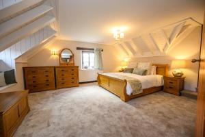 a bedroom with a king sized bed and wooden furniture at Laurel House - Pool, Sauna & Gardens - Sleeps up to 12 people by STAE-Homes in Magor
