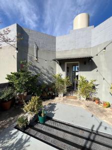 a white house with a patio with plants at Depto Berazategui Centro in Berazategui