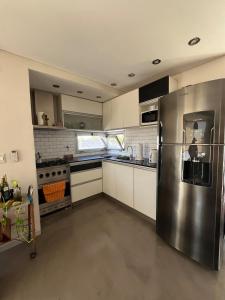 a large kitchen with a stainless steel refrigerator at Depto Berazategui Centro in Berazategui