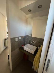a bathroom with a sink and a mirror at Depto Berazategui Centro in Berazategui +14 photos