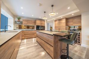 a kitchen with wooden cabinets and a bar with a chair at Elder howe in Penrith