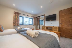 a bedroom with two beds and a flat screen tv at Elder howe in Penrith