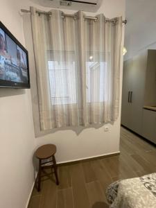 a room with a window with a chair and a table at Mare Studio by All Around in Heraklio