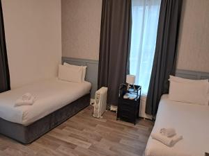 a hotel room with two beds and a window at Saint Annes Guest House - 22 Berkeley in Dublin +67 photos