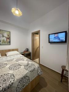 a bedroom with a bed and a tv on the wall at Mare Studio by All Around in Heraklio