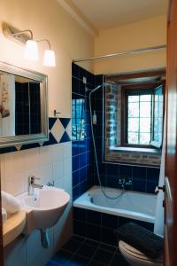 a blue tiled bathroom with a sink and a tub at xenonas ton xromaton - Guest house of colors in Lafkos +87 photos