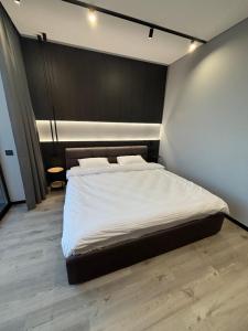 a bedroom with a large bed with a black headboard at Bavaro apartments 3 in Ivano-Frankivsk