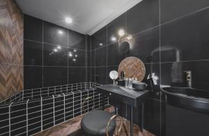 a black bathroom with a sink and a mirror at My loft ChengDu in Chengdu