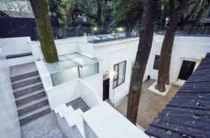 a white building with a staircase and trees at My loft ChengDu in Chengdu