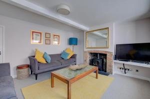 a living room with a couch and a fireplace at 5 Bed in Southwold oc-hjames in Southwold