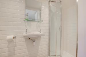 a white bathroom with a sink and a shower at 5 Bed in Southwold oc-hjames in Southwold