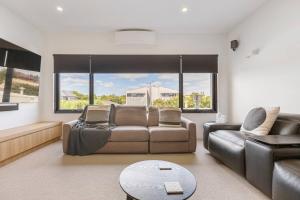 a living room with a leather couch and a table at The Pool Pavilion - Where City meets Beach in Melbourne