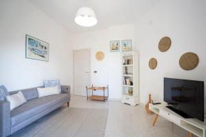 a living room with a couch and a television at CAPOVILLAS - Villa Laura with private pool in Vibo Valentia