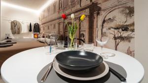 a table with a black bowl and glasses on it at DOMUS 1435 - Iconic Suites in Centro in Mantova
