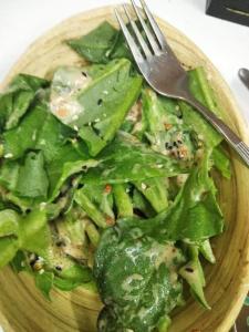 a plate of greens with a fork and a salad at Moktan Homestay in Pakhyong