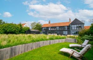 a yard with two chairs and a house at 5 Bed in Walberswick oc-lev in Walberswick