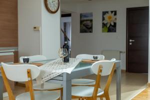 a dining room with a blue table and white chairs at Petra's Skyline in Suceava