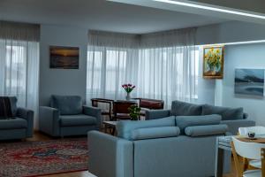 a living room with blue couches and a table at Petra's Skyline in Suceava