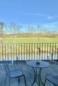 eine Terrasse mit Tisch und Stühlen auf einem Deck in der Unterkunft Hotel Nenuphar in Gent
