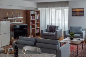 a living room with a couch and chairs and a tv at Petra's Skyline in Suceava +30 photos