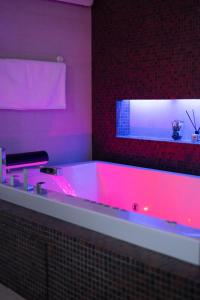 a bathroom with a tub with pink lighting at Petra's Skyline in Suceava