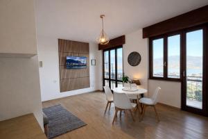 a dining room with a table and chairs and windows at Bella Vista Baveno in Baveno