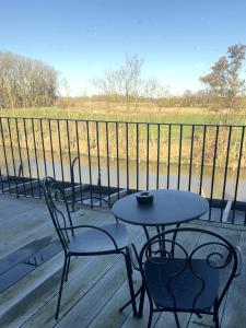 Ein Tisch und Stühle auf einer Veranda mit Blick auf ein Feld in der Unterkunft Hotel Nenuphar in Gent + 37 Fotos