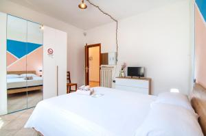 a white bedroom with a bed and a tv at Emi&Marti House in Mozzecane