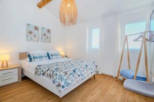 a white bedroom with a bed and a chair at GuestReady - Sea Escape Azores in Lagoa