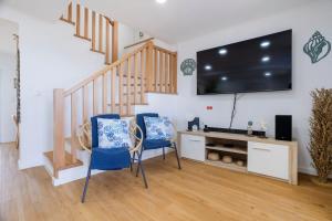 a living room with two chairs and a large screen tv at GuestReady - Sea Escape Azores in Lagoa