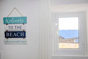 a welcome to the beach sign in front of a door at GuestReady - Sea Escape Azores in Lagoa +71 photos