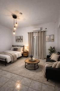 a bedroom with a bed and a couch and a table at Olive tree Apartment Kanoni in Kanoni