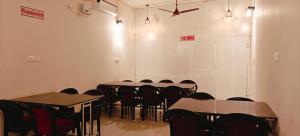 a conference room with tables and chairs and a ceiling at Sukra Residency in Valavanūr