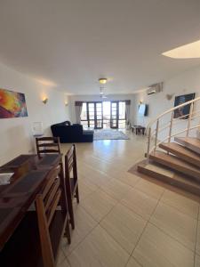 a living room with a couch and a table and stairs at Ocean Crown Apartments in Mombasa