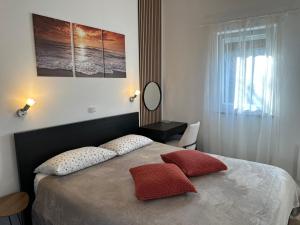 a bedroom with a bed with two pillows on it at Holiday Home Kerniat in Pula