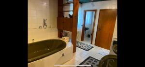 a bathroom with a green bath tub in a room at Ferienhaus Natternberg Spacious apartment large living room 4 bedrooms garden quiet near Deggendorf in Deggendorf +14 photos