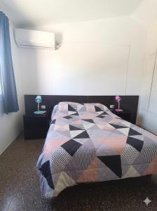 a bedroom with a bed with a quilt on it at Apartamento duplex único en Carmelo in Carmelo