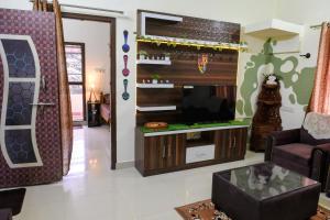 a living room with a tv and a couch at Aura attic residency in Bangalore