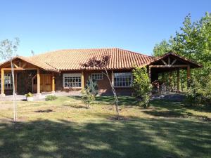 a house with a shingled roof in a yard at Casa de Campo, tranquilidad natural in Curicó