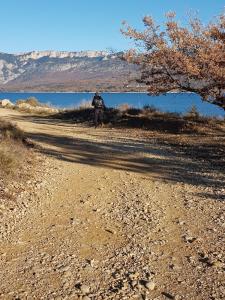 a person standing on a dirt road next to a body of water at Logis du Grand Puits in Baudinard