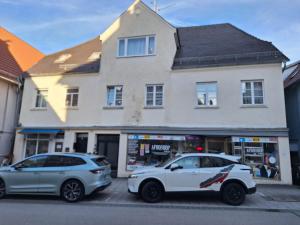 two cars parked in front of a building at Delblaiso Suite in Memmingen
