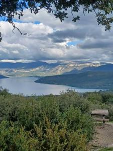 a bench sitting on top of a hill overlooking a lake at Logis du Grand Puits in Baudinard