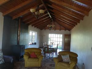 a living room with two chairs and a table with a fireplace at Casa de Campo, tranquilidad natural in Curicó