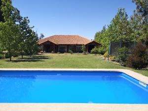 a house with a blue swimming pool in front of it at Casa de Campo, tranquilidad natural in Curicó
