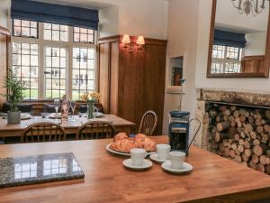a kitchen and dining room with a table with bread on it at Ostlers in Burford