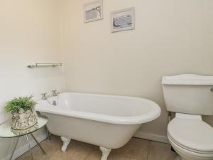 a bathroom with a white tub and a toilet at Ostlers in Burford +29 photos