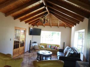 a living room with couches and a tv and a table at Casa de Campo, tranquilidad natural in Curicó