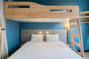 a bedroom with a bunk bed with a ladder at ibis budget Genève Aéroport in Geneva +81 photos